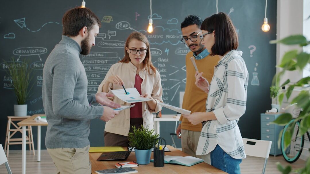 Team of coaches reviewing notes together in a bright office
